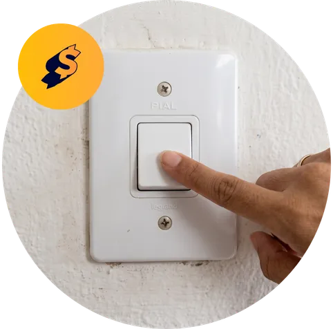 Mão apertando o interruptor de luz na parede